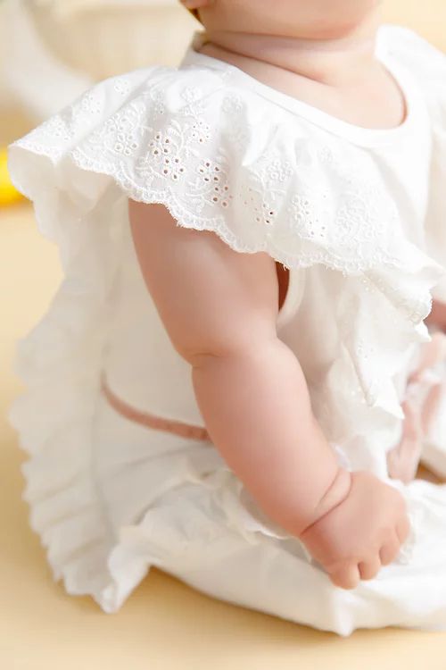 close up of white baby jumpsuit